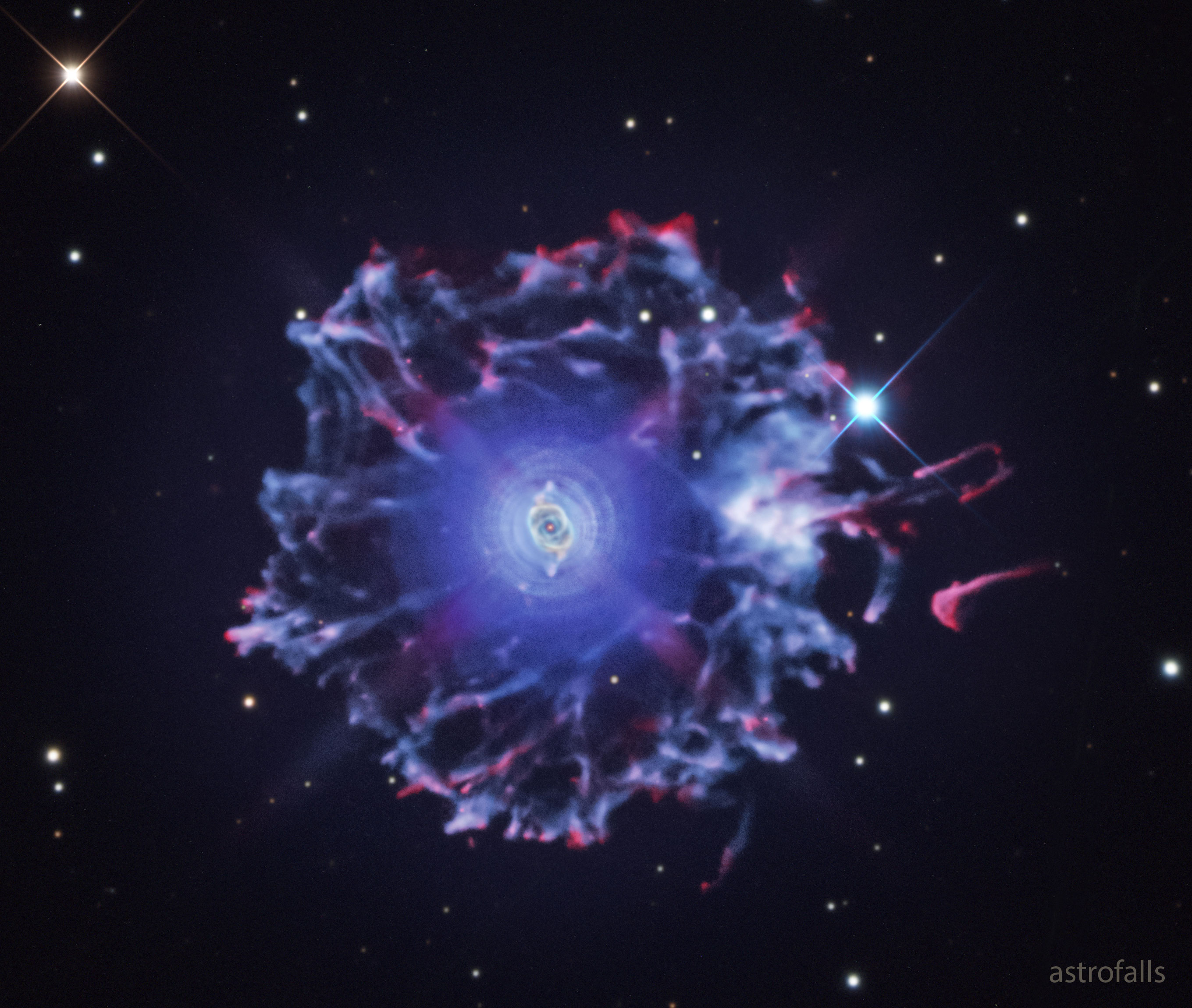 What created the unusual halo around the Cat's Eye nebula? No one is sure. What is sure is that the Cat's Eye Nebula (NGC 6543) is one of the best known planetary nebulae on the sky. Although haunting symmetries are seen in the bright central region, this image was taken to feature its intricately structured outer halo, which spans over three light-years across. Planetary nebulae have long been appreciated as a final phase in the life of a Sun-like star. Only recently however, have some planetaries been found to have expansive halos, likely formed from material shrugged off during earlier puzzling episodes in the star's evolution. While the planetary nebula phase is thought to last for around 10,000 years, astronomers estimate the age of the outer filamentary portions of the Cat's Eye Nebula's halo to be 50,000 to 90,000 years.