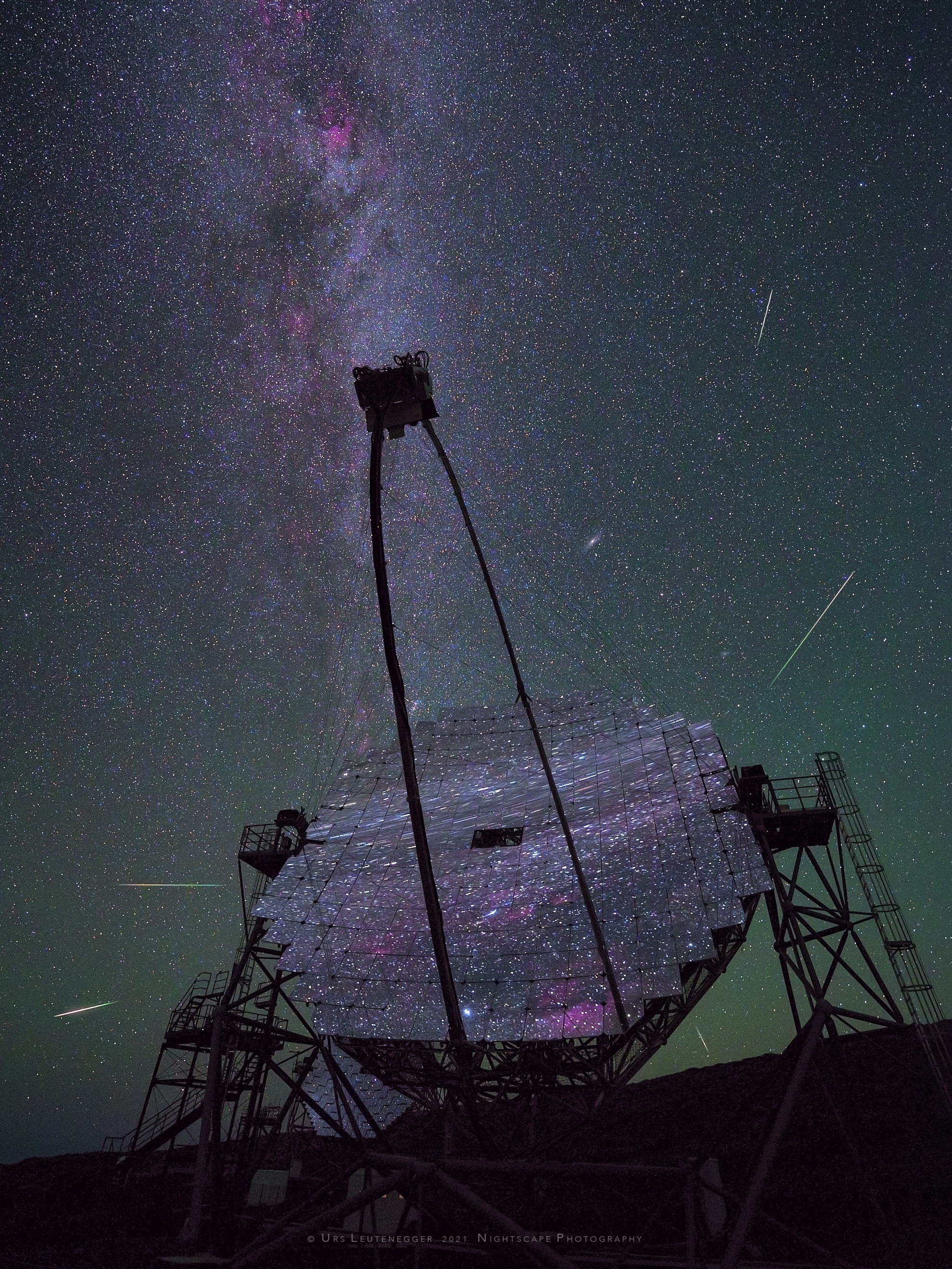On August 11, 2021 a multi-mirror, 17 meter-diameter MAGIC telescope reflected this starry night sky from the Roque de los Muchachos European Northern Observatory on the Canary Island of La Palma. MAGIC stands for Major Atmospheric Gamma Imaging Cherenkov. The telescopes can see the brief flashes of optical light produced in particle air showers as high-energy gamma rays impact the Earth's upper atmosphere. To the dark-adapted eye the mirror segments offer a tantalizing reflection of stars and nebulae along the plane of our Milky Way galaxy. But directly behind the segmented mirror telescope, low on the horizon, lies the constellation Perseus. And on that date the dramatic composite nightscape also captured meteors streaming from the radiant of the annual Perseid meteor shower. This year the Perseid shower activity will again peak around August 13 but perseid meteors will have to compete with the bright light of a Full Moon.