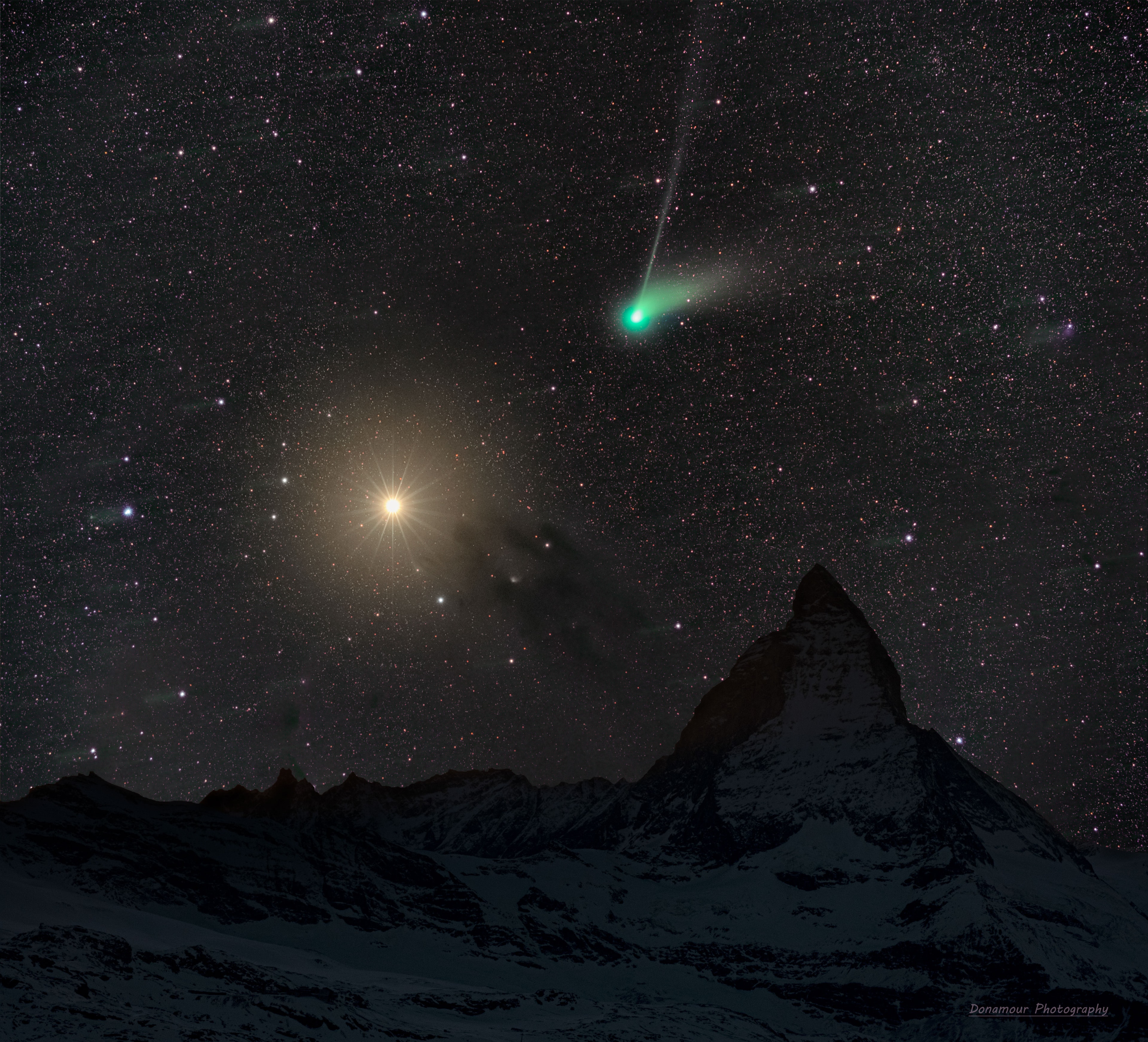 No, Comet ZTF is not going to hit Mars. Nicknamed the Green Comet for its bright green coma, C/2022 E3 (ZTF) did, however, pass almost in front of the much-more distant planet a few days ago, very near in time to when the featured picture was taken. The two sky icons were here captured behind a famous Earth icon -- the Matterhorn, a mountain in the Alps between Switzerland and Italy with a picturesque peak. Both the foreground and background images were taken on the same evening by the same camera and from the same location. The comet's white dust tail is visible to the right of the green coma, while the light blue ion tail trails towards the top of the image. Orange Mars is well in front of the numerous background stars as well as the dark nebula Barnard 22 to its lower right. Although Mars remains visible in the evening sky for the next few months, Comet ZTF has already begun to fade as it returns to the outer Solar System. Comet ZTF Gallery: Notable Submissions to APOD