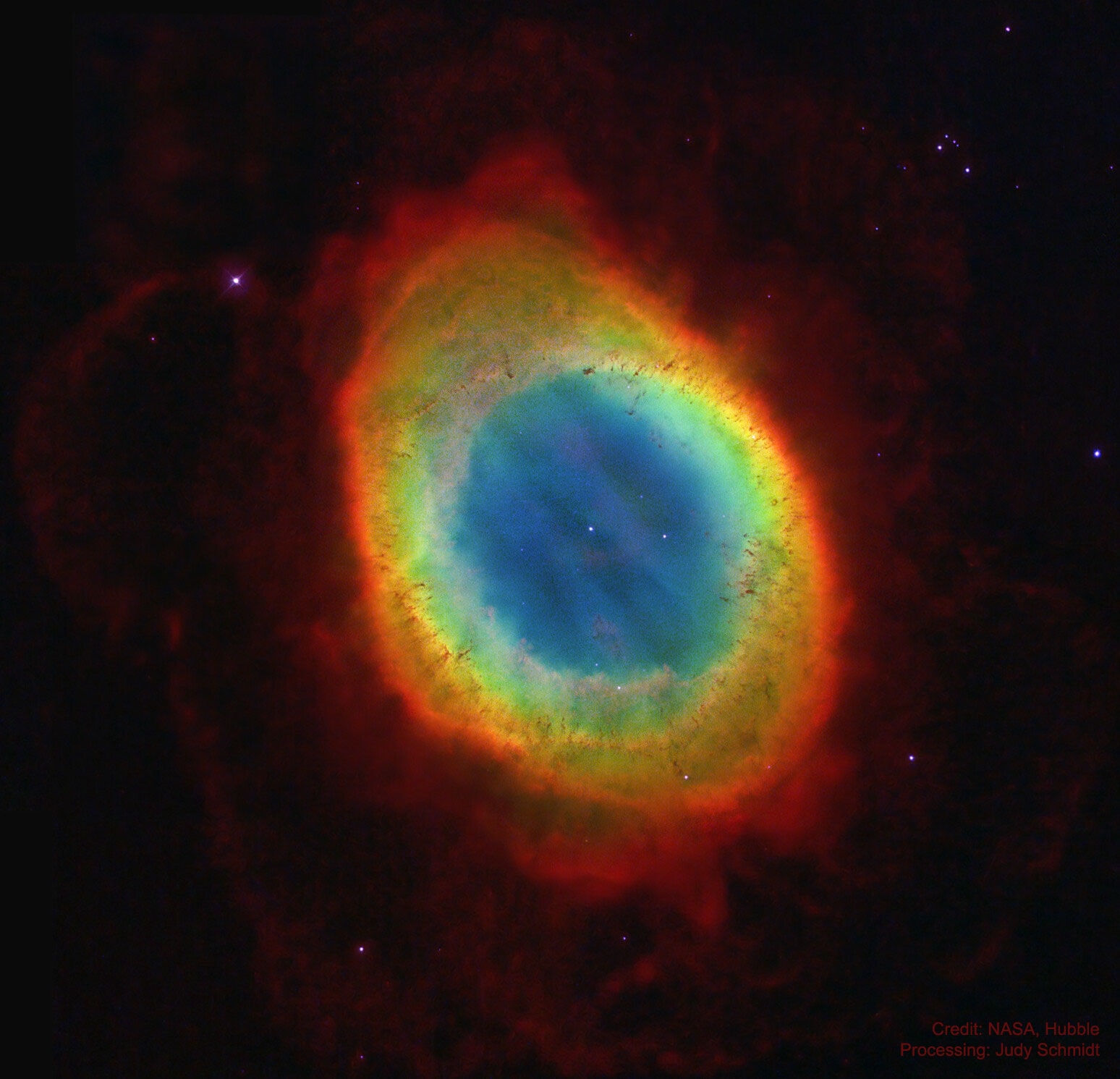 It was noticed hundreds of years ago by stargazers who could not understand its unusual shape. It looked like a ring on the sky. Except for the rings of Saturn, the Ring Nebula (M57) may be the most famous celestial circle. We now know what it is, and that its iconic shape is due to our lucky perspective. The recent mapping of the expanding nebula's 3-D structure, based in part on this clear Hubble image,indicates that the nebula is a relatively dense, donut-like ring wrapped around the middle of an (American) football-shaped cloud of glowing gas. Our view from planet Earth looks down the long axis of the football, face-on to the ring. Of course, in this well-studied example of a planetary nebula, the glowing material does not come from planets. Instead, the gaseous shroud represents outer layers expelled from the dying, once sun-like star, now a tiny pinprick of light seen at the nebula's center. Intense ultraviolet light from the hot central star ionizes atoms in the gas. The Ring Nebula is about one light-year across and 2,500 light-years away.