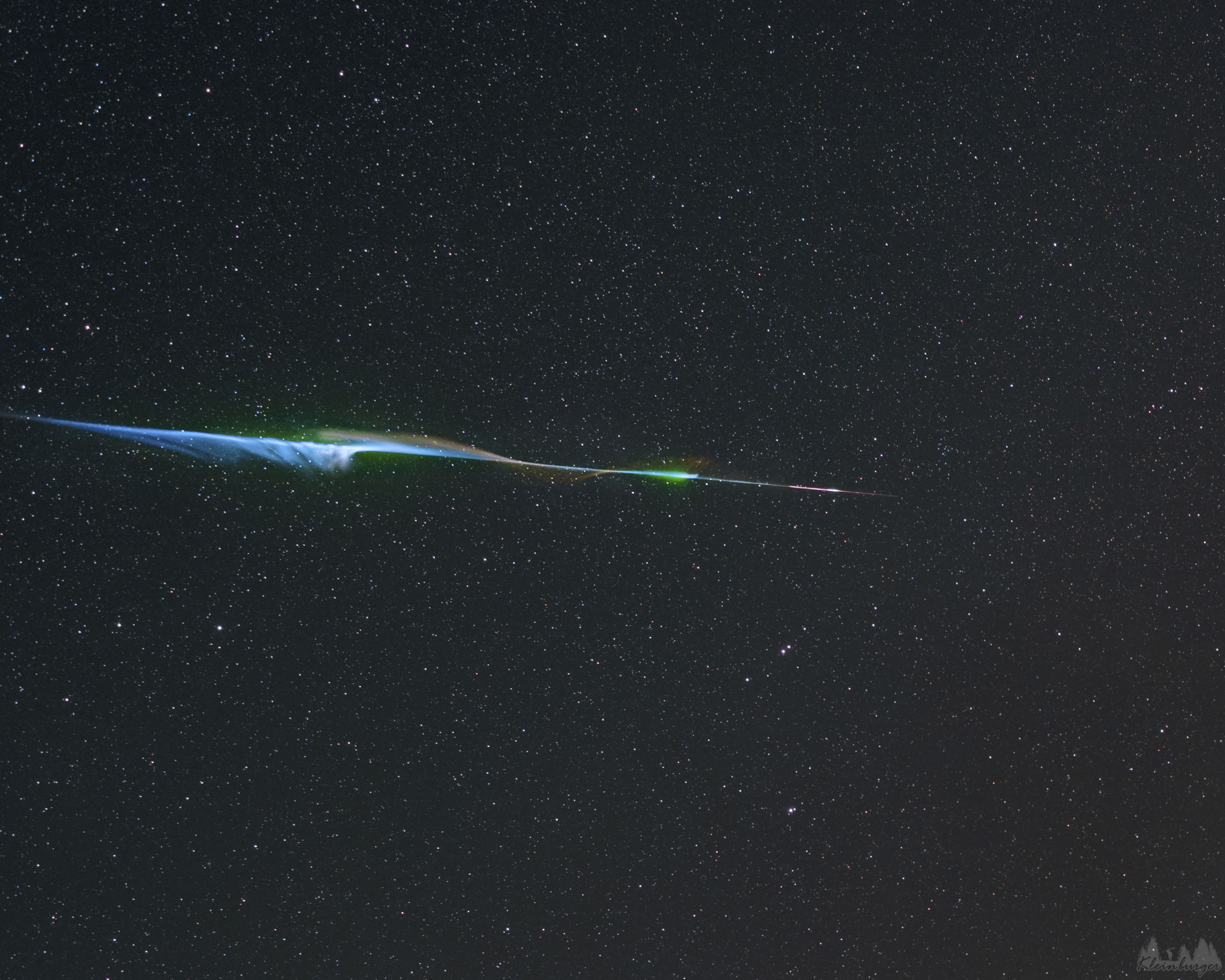 Meteors can be colorful. While the human eye usually cannot discern many colors, cameras often can. Pictured here is a fireball, a disintegrating meteor that was not only one of the brightest the photographer has ever seen, but colorful. The meteor was captured by chance in mid-July with a camera set up on Hochkar Mountain in Austria to photograph the central band of our Milky Way galaxy. The radiant grit, likely cast off by a comet or asteroid long ago, had the misfortune to enter Earth's atmosphere. Colors in meteors usually originate from ionized chemical elements released as the meteor disintegrates, with blue-green typically originating from magnesium, calcium radiating violet, and nickel glowing green. Red, however, typically originates from energized nitrogen and oxygen in the Earth's atmosphere. This bright meteoric fireball was gone in a flash -- less than a second -- but it left a wind-blown ionization trail that remained visible for almost a minute.