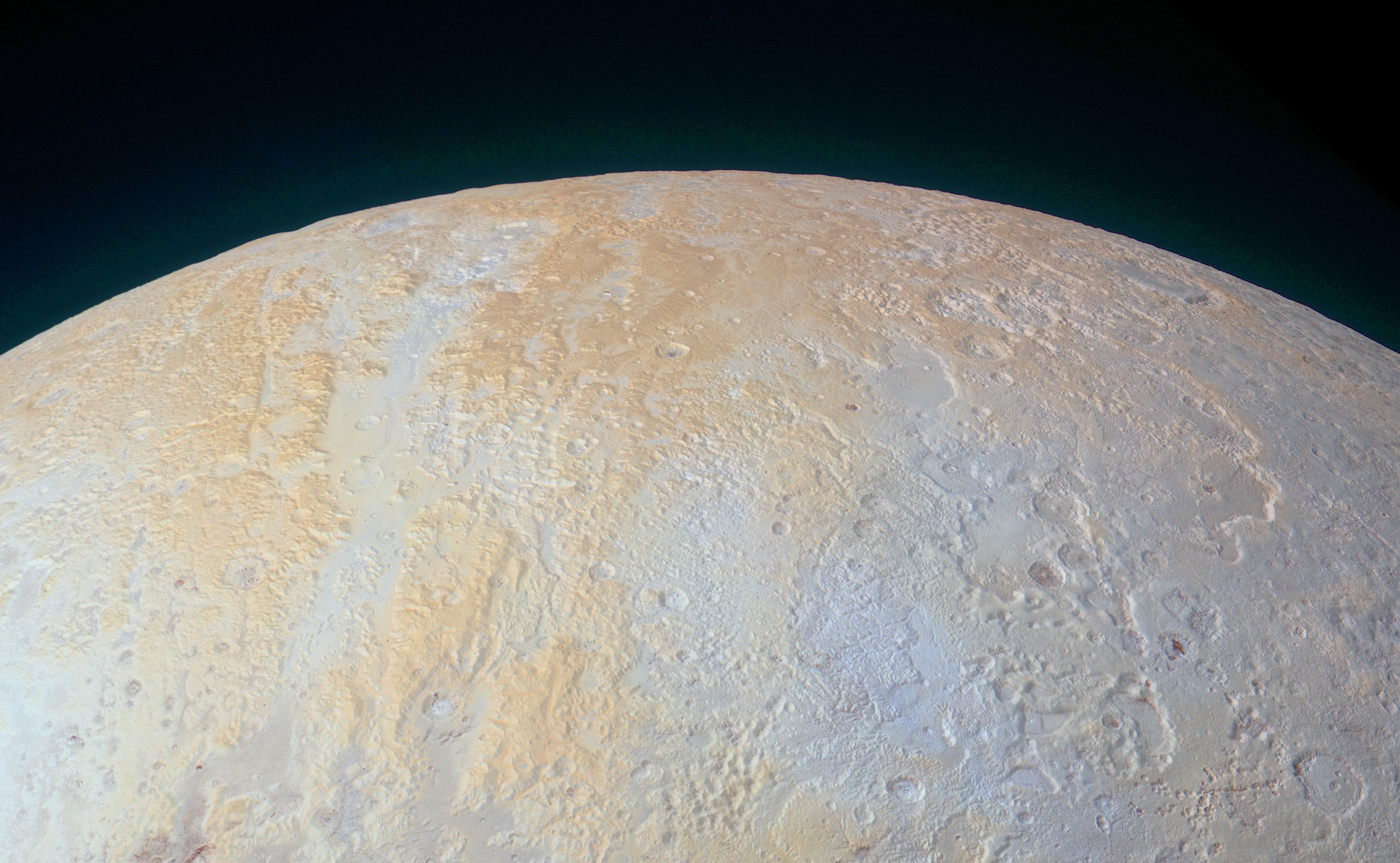 Gaze across the frozen canyons of northern Pluto in this contrast enhanced color scene. The image data used to construct it was acquired in July 2015 by the New Horizons spacecraft as it made the first reconnaissance flight through the remote Pluto system six billion kilometers from the Sun. Now known as Lowell Regio, the region was named for Percival Lowell, founder of the Lowell Observatory. Also famous for his speculation that there were canals on Mars, Lowell started the search that ultimately led to Pluto's discovery in 1930 by Clyde Tombaugh. In this frame Pluto's North Pole is above and left of center. The pale bluish floor of the broad canyon on the left is about 70 kilometers (45 miles) wide, running vertically toward the south. Higher elevations take on a yellowish hue. New Horizon's measurements were used to determine that in addition to nitrogen ice, methane ice is abundant across Lowell Regio. So far, Pluto is the only Solar System world named by an 11-year-old girl.