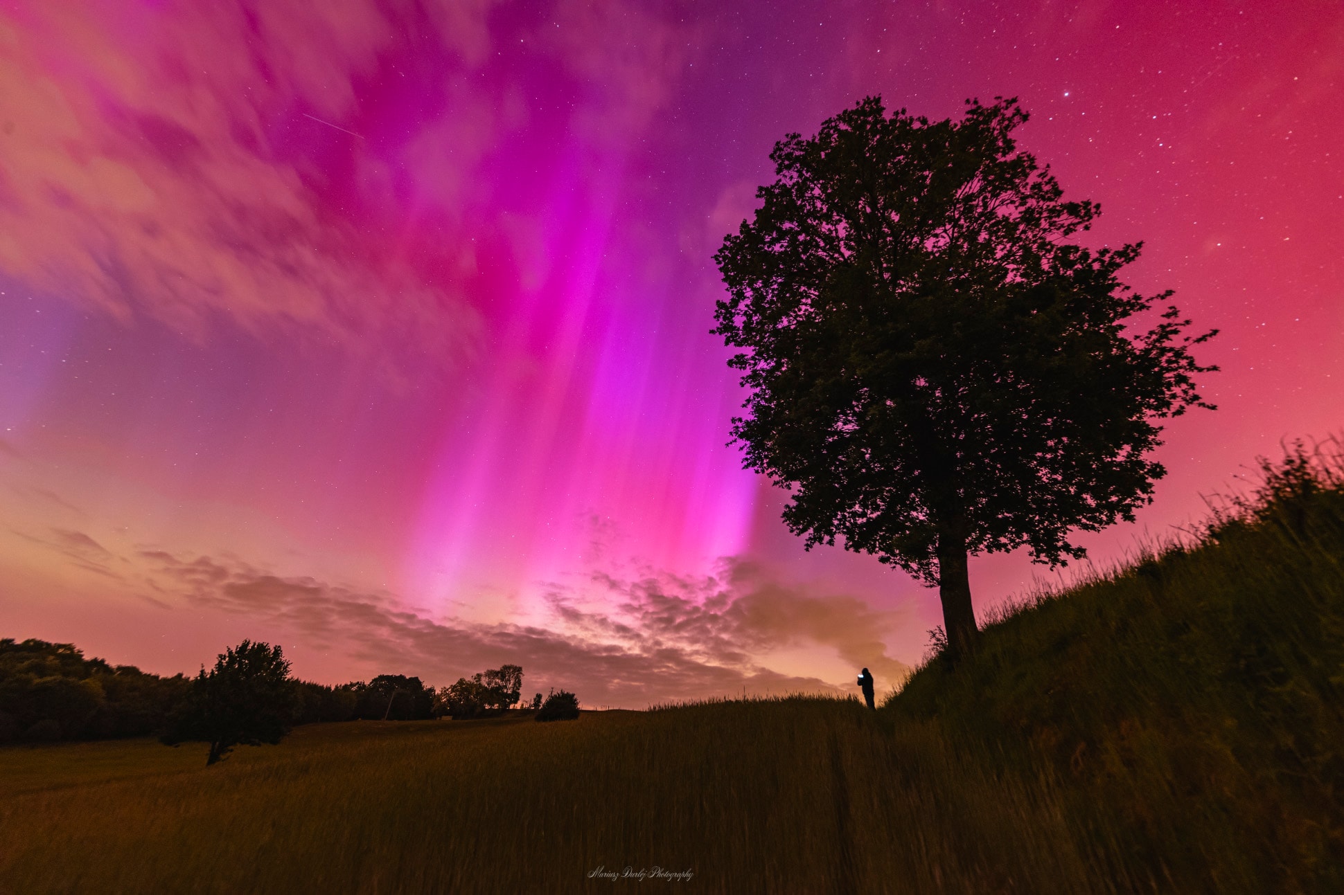 Northern lights don't usually reach this far south. Magnetic chaos in the Sun's huge Active Region 3664, however, produced a surface explosion that sent a burst of electrons, protons, and more massive, charged nuclei into the Solar System. A few days later, that coronal mass ejection (CME) impacted the Earth and triggered auroras that are being reported unusually far from our planet's north and south poles. The free sky show might not be over -- the sunspot rich AR3664 has ejected even more CMEs that might also impact the Earth tonight or tomorrow. That active region is now near the Sun's edge, though, and will soon be rotating away from the Earth. Pictured, a red and rayed aurora was captured in a single 6-second exposure from Racibórz, Poland early last night. The photographer's friend, seeing an aurora for the first time, is visible in the distance also taking images of the beautifully colorful nighttime sky. Gallery: Global Aurora from Solar Active Region 3664