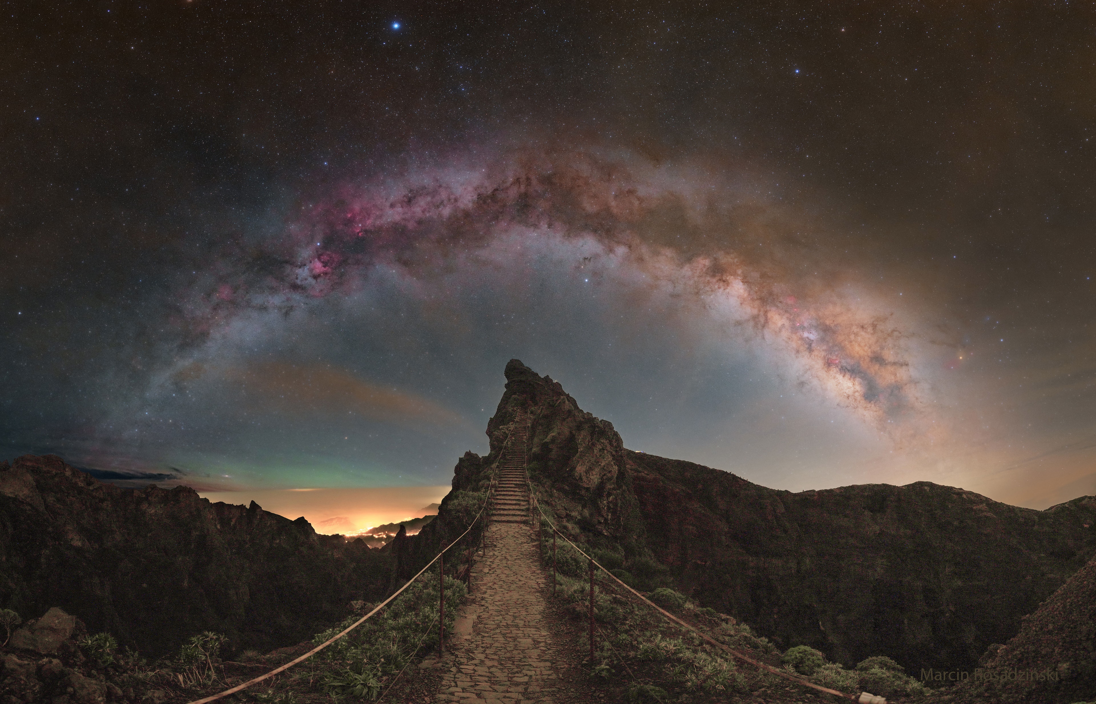 What happens if you ascend this stairway to the Milky Way? Before answering that, let's understand the beautiful sky you will see. Most eye-catching is the grand arch of the Milky Way Galaxy, the band that is the central disk of our galaxy which is straight but distorted by the wide-angle nature of this composite image. Many stars well in front of the Milk Way will be visible, with the bright white star just below the stellar arch being Altair, and the bright blue star above it being Vega. The air glows green on the left, just above the yellow cloud deck. The featured image was taken last month on Portugal's Madeira Island in the North Atlantic Ocean. Oh, and what happens after you reach the top of these stairs and admire the amazing sky is, quite probably, that you then descend down the stairs on the other side. Your Sky Surprise: What picture did APOD feature on your birthday? (post 1995)