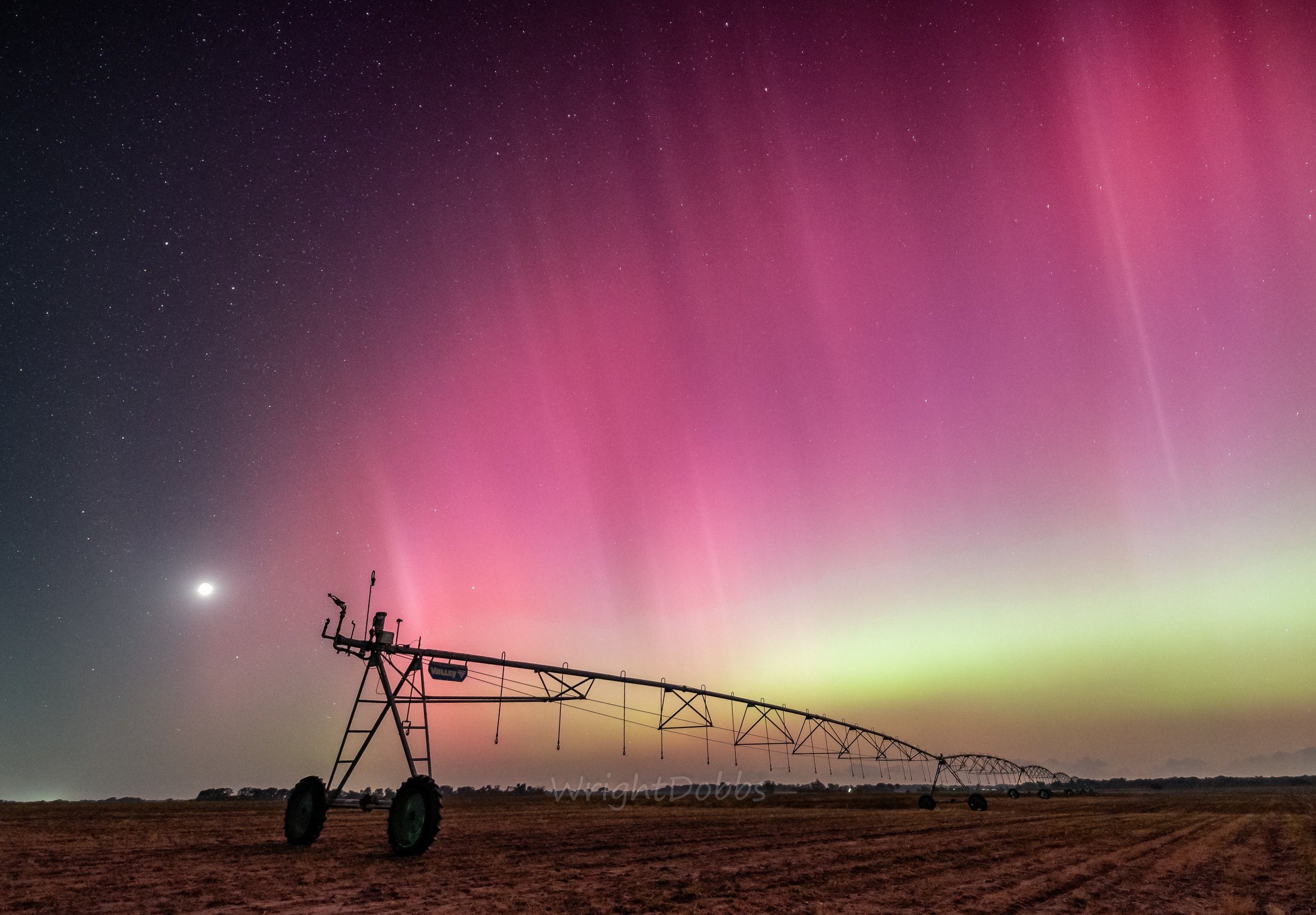 A familiar sight from Georgia, USA, the Moon sets near the western horizon in this rural night skyscape. Captured on May 10 before local midnight, the image overexposes the Moon's bright waxing crescent at left in the frame. A long irrigation rig stretches across farmland about 15 miles north of the city of Bainbridge. Shimmering curtains of aurora shine across the starry sky, definitely an unfamiliar sight for southern Georgia nights. Last weekend, extreme geomagnetic storms triggered by the recent intense activity from solar active region AR 3664 brought epic displays of aurora, usually seen closer to the poles, to southern Georgia and even lower latitudes on planet Earth. As solar activity ramps up, more storms are possible. AuroraSaurus: Report your aurora observations