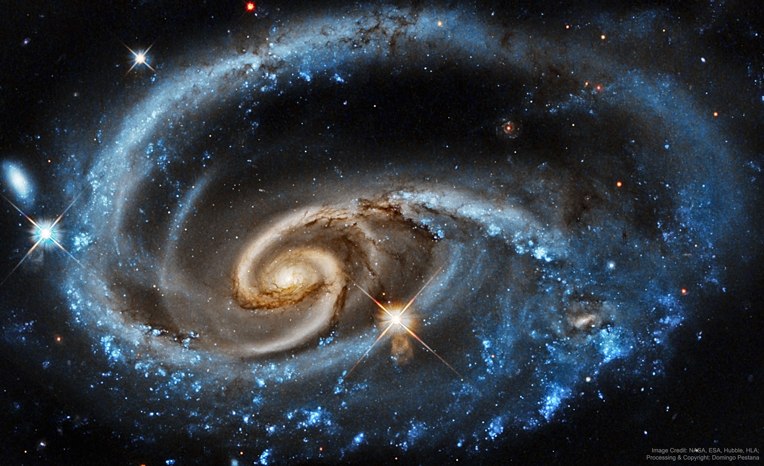 What's happening to this spiral galaxy? Although details remain uncertain, it surely has to do with an ongoing battle with its smaller galactic neighbor. The featured galaxy is labelled UGC 1810 by itself, but together with its collisional partner is known as Arp 273. The overall shape of UGC 1810 -- in particular its blue outer ring -- is likely a result of wild and violent gravitational interactions. This ring's blue color is caused by massive stars that are blue hot and have formed only in the past few million years. The inner galaxy appears older, redder, and threaded with cool filamentary dust. A few bright stars appear well in the foreground, unrelated to UGC 1810, while several galaxies are visible well in the background. Arp 273 lies about 300 million light years away toward the constellation of Andromeda. Quite likely, UGC 1810 will devour its galactic sidekick over the next billion years and settle into a classic spiral form.