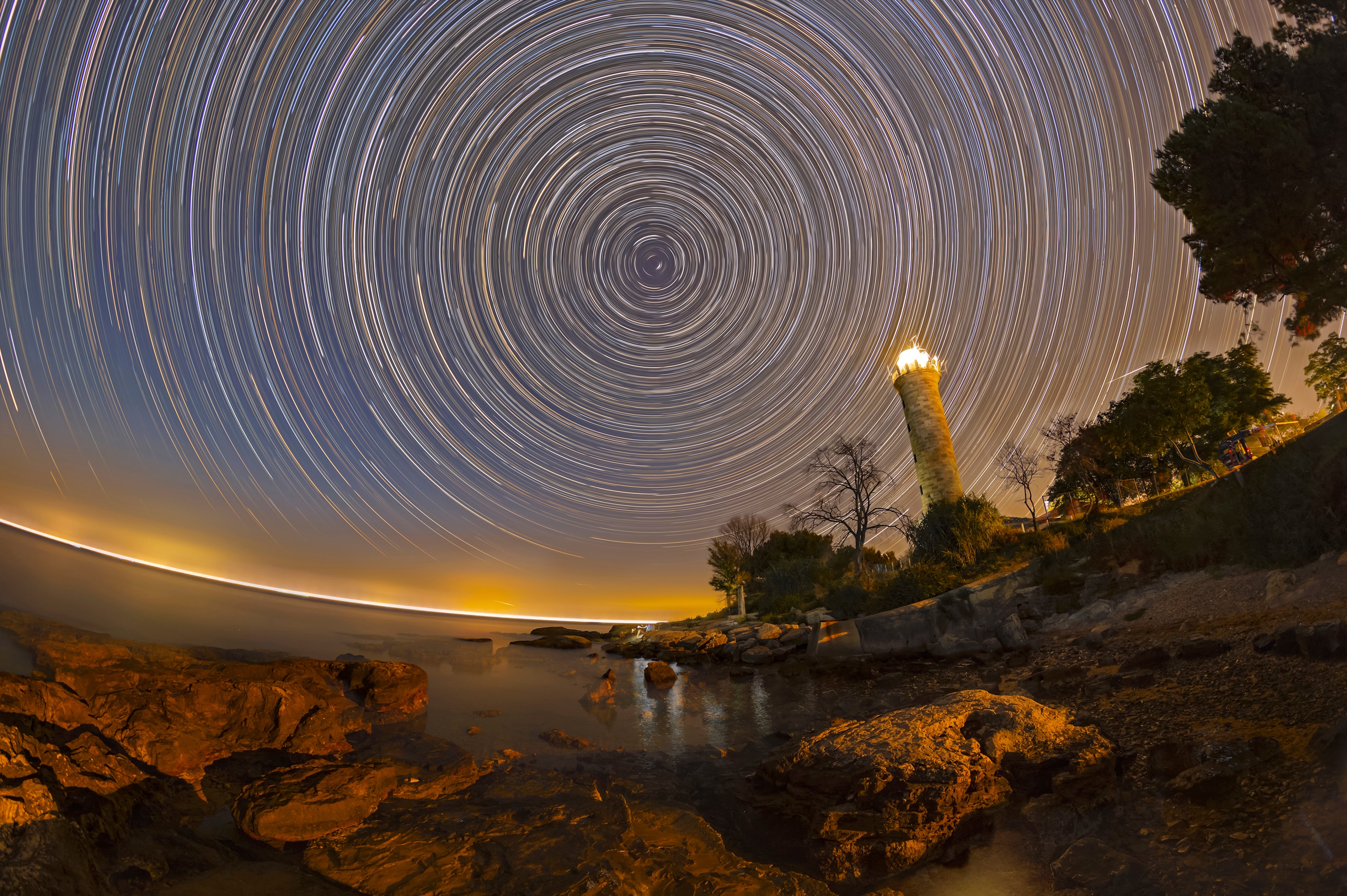 Savudrija lighthouse shines along the coast near the northern end of the Istrian peninsula in this well-composed night skyscape. A navigational aid for sailors on the Adriatic Sea, the historic lighthouse was constructed in the early 19th century. But Polaris, an even older aid to navigation, shines in the sky above. Alpha star of the constellation Ursa Minor, Polaris is also known as the North Star. In this scene Polaris forms the shortest bright arc near the North Celestial Pole, the extension of Earth's axis of rotation into space. Of course, the North Celestial Pole lies exactly at the center of all the concentric star trails. The composite image is a digital stack of 400 exposures, each 30 seconds long, taken with camera and tripod fixed to a rotating planet.