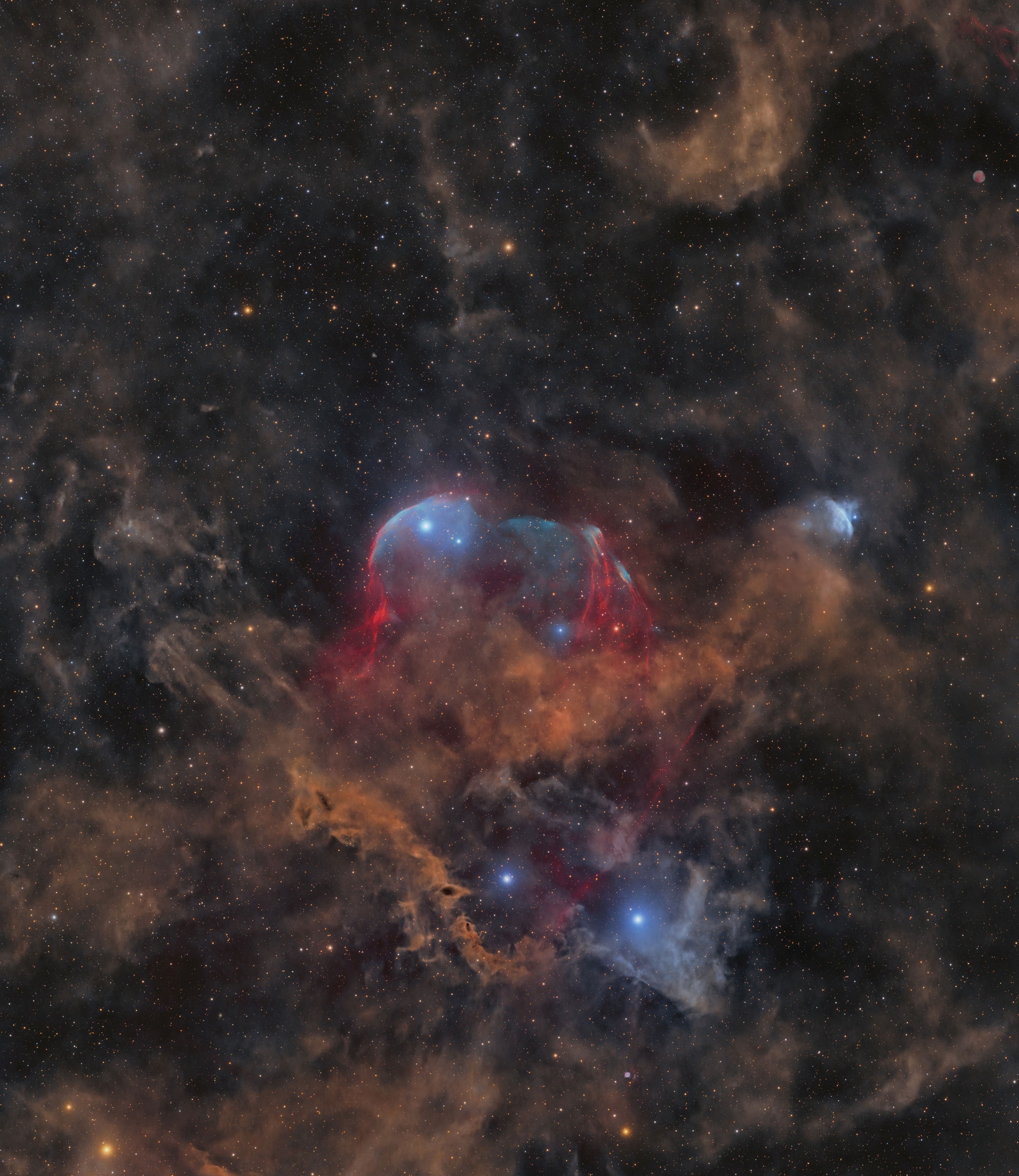 Can you identify this celestial object? Likely not — because this is a discovery image. Massive stars forge heavy elements in their cores and, after a few million years, end their lives in powerful supernova explosions. These remnants cool relatively quickly and fade, making them difficult to detect. To uncover such faint, previously unknown supernova remnants, a dedicated group of amateur astrophotographers searched through sky surveys for possible supernova remnant candidates. The result: the first-ever image of supernova remnant G115.5+9.1 — named Scylla by its discoverers—glowing faintly in the constellation of the mythological King of Aethiopia: Cepheus. Emission from hydrogen atoms in the remnant is shown in red, and faint emission from oxygen is shown in hues of blue. Surprisingly, another discovery lurked to the upper right: a faint, previously unknown planetary nebula candidate. In keeping with mythological tradition, it was named Charybdis (Sai 2) — a nod to the ancient Greek expression "caught between Scylla and Charybdis" from Homer’s Odyssey.