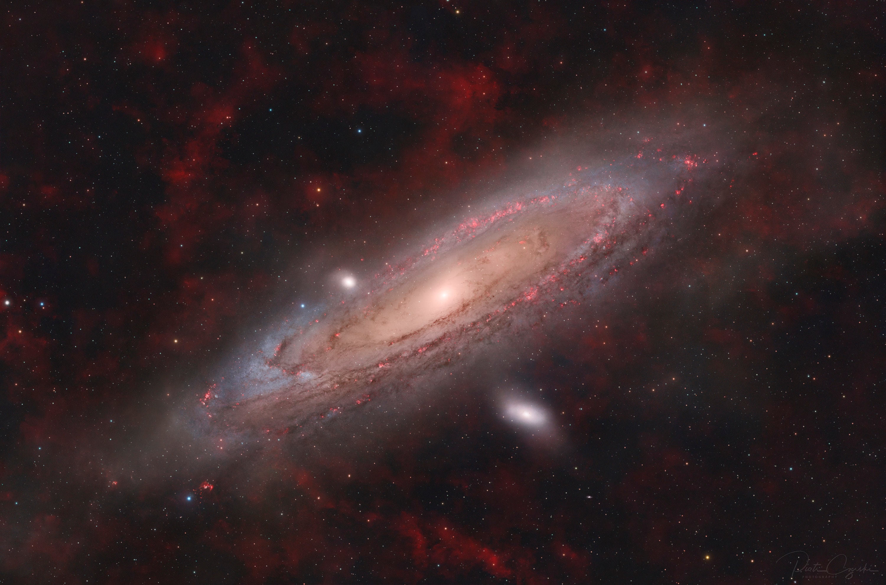 This magnificent extragalactic skyscape looks toward the Andromeda Galaxy, the closest large spiral galaxy to the Milky Way. It also accomplishes a Messier catalog trifecta by including Andromeda, cataloged as Messier 31 (M31), along with Messier 32 (M32), and Messier 110 (M110) in the same telescopic field of view. In this frame, M32 is just left of the Andromeda Galaxy's bright core with M110 below and to the right. M32 and M110 are both elliptical galaxies themselves and satellites of the larger spiral Andromeda. By combining 60 hours of broadband and narrowband image data, the deep telescopic view also reveals tantalizing details of dust lanes, young star clusters, and star-forming regions along Andromeda's spiral arms, and faint, foreground clouds of glowing hydrogen gas. For now, Andromeda and friends are some 2.5 million light-years from our own large spiral Milky Way. Fun Fact: It has been 11,111 days since APOD was founded.