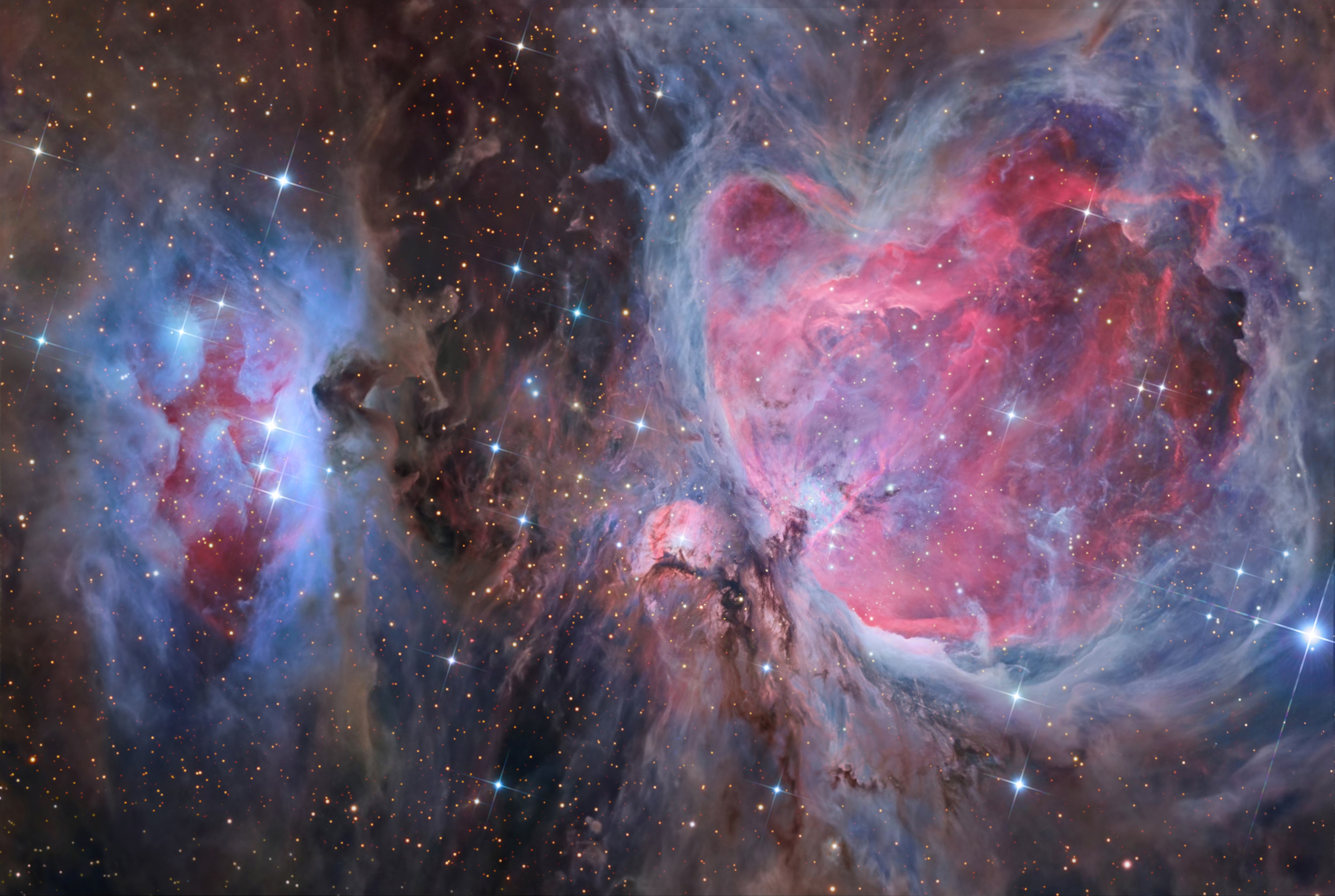Few cosmic vistas can excite the imagination like The Great Nebula in Orion. Visible as a faint, bland celestial smudge to the naked-eye, the nearest large star-forming region sprawls across this sharp colorful telescopic image. Designated M42 in the Messier Catalog, the Orion Nebula's glowing gas and dust surrounds hot, young stars. About 40 light-years across, M42 is at the edge of an immense interstellar molecular cloud only 1,500 light-years away that lies within the same spiral arm of our Milky Way galaxy as the Sun. Including dusty bluish reflection nebula NGC 1977, also known as the Running Man nebula at left in the frame, the natal nebulae represent only a small fraction of our galactic neighborhood's wealth of star-forming material. Within the well-studied stellar nursery, astronomers have also identified what appear to be numerous infant solar systems.