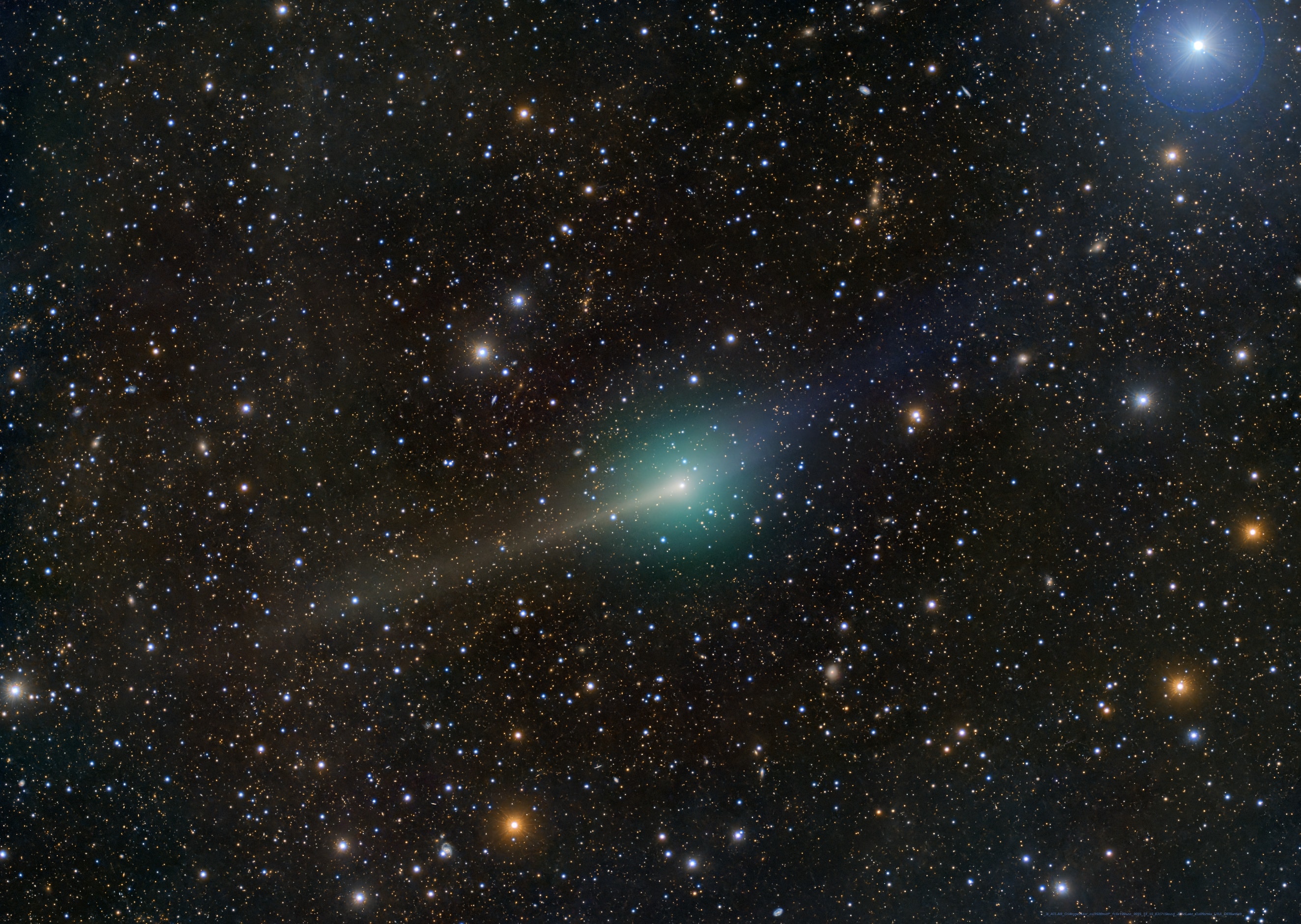 Attention grabbing interstellar visitor 3I/ATLAS made its not-so-close flyby of our fair planet on December 19 at a distance of 1.8 astronomical units. That's about 900 light-seconds. This deep exposure captures the comet from another star system as it gently swept across a faint background of stars in the constellation Leo about 4 days earlier. Though faint, colors emphasized in the image data show off the comet's yellowish dust tail and bluish ion tail along with a greenish tinged coma. And even as it is scrutinized by arrays of telescopes and spacecraft from planet Earth, 3I/ATLAS is headed out of the Solar System. It's presently moving outward along a hyperbolic trajectory at about 64 kilometers per second relative to the Sun, too fast to be bound by the Sun's gravity.