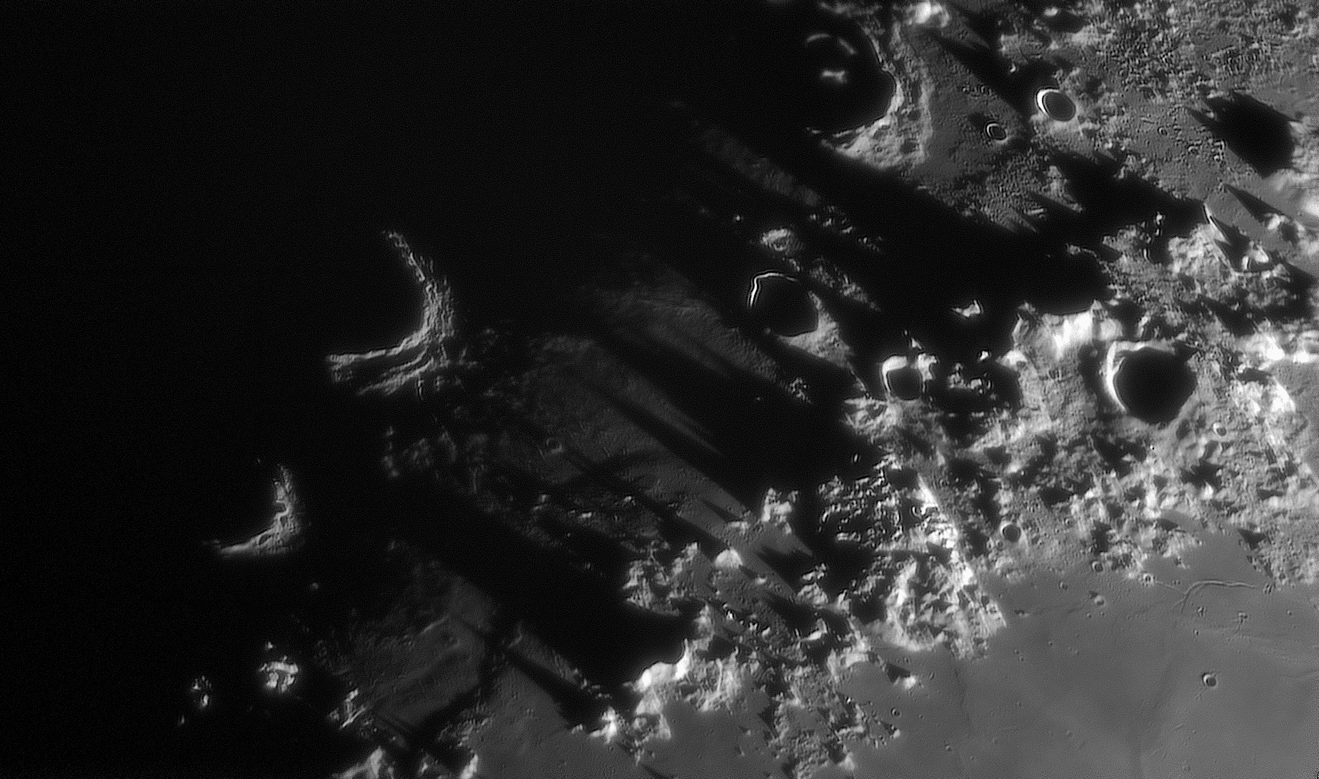 When the Moon is at its first quarter phase, the Sun rises along the Montes Caucasus as seen from the lunar surface. The lunar mountain range casts the magnificent, spire-like shadows in this telescopic view from planet Earth, looking along the lunar terminator or the boundary between lunar night and day. Named for Earth's own Caucasus Mountains, the rugged lunar Montes Caucasus peaks, up to 6 kilometers high, are located between the smooth Mare Imbrium to the west and Mare Serenitatis to the east. Still mostly in shadow in this first quarter lunarscape, at the left (west) impact craters reflect the light of the rising Sun along their outer, eastern crater walls.