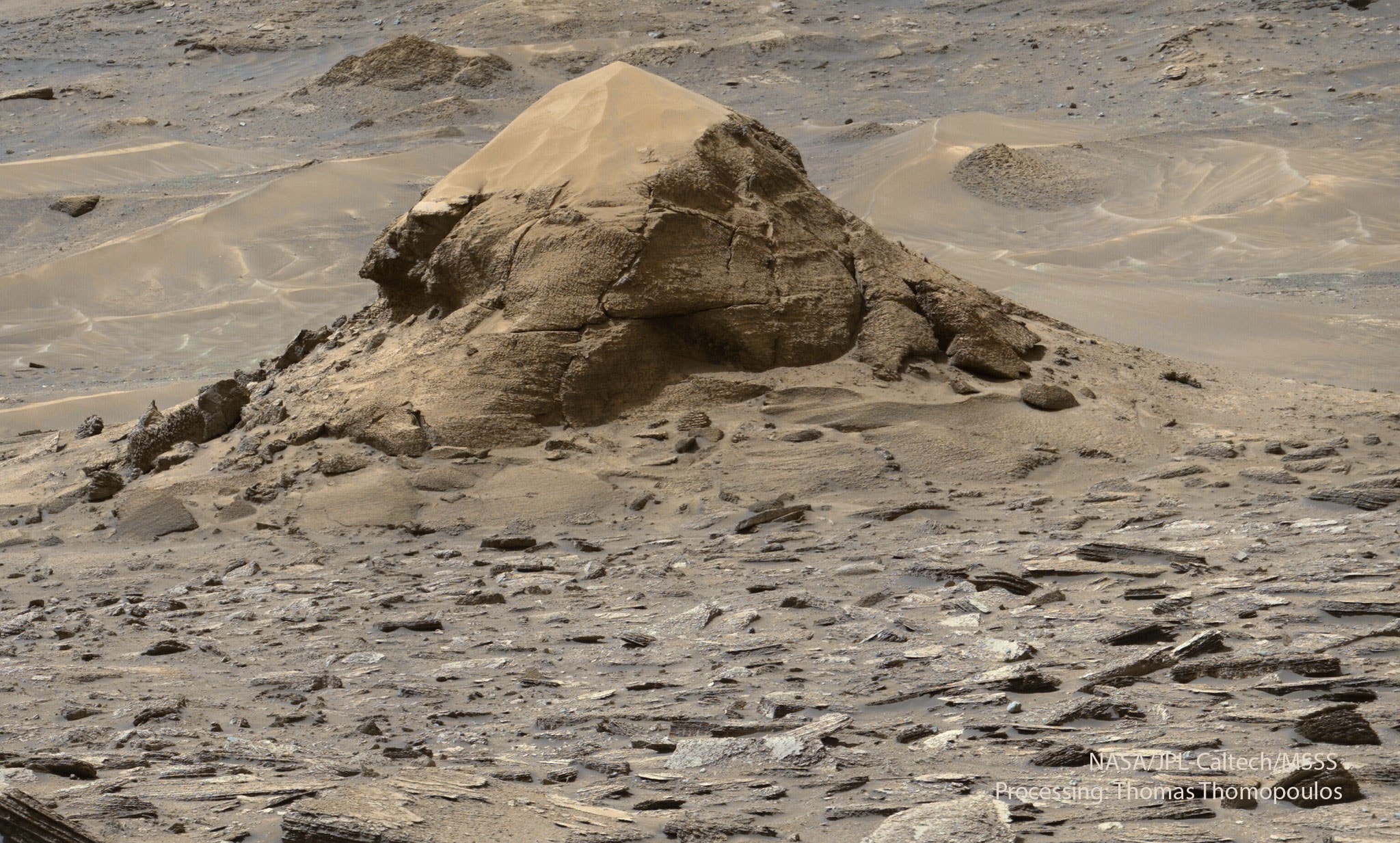 Is this a fossilized turtle on Mars? No. Although resembling a large Earth tortoise, this is a layered rock outcrop on Mars that is estimated to span about 15 meters, making it much larger than turtles on Earth. NASA’s robotic Curiosity rover came across this unusual mound, dubbed Miraflores, last month during its 4922nd Martian day exploring Mars. The small butte may survive because it was somehow more resistant to erosion than surrounding rock. More recent wind has now covered its top with orange Martian sand. Below the top shell, many layers of stratified rock are visible, possibly indicating a long history of intermittent wind-blown sand being deposited and then hardened by ground water. Similar wind-eroded layered landforms, such as yardangs in the Qaidam Desert of China, exist here on Earth. Curiosity and its companion rover Perseverance continue to investigate the ancient history of Mars as well as searching for signs of primeval life.